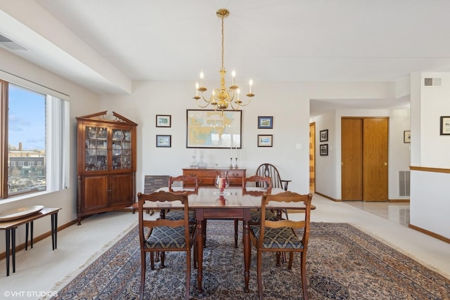 dining space featuring a chandelier and carpet floors