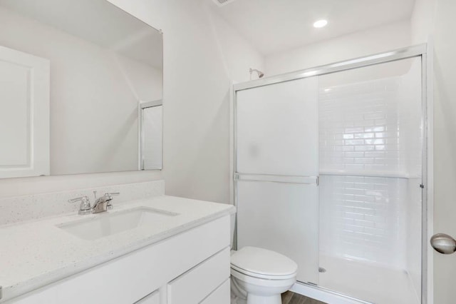 bathroom with vanity, toilet, and a shower with shower door