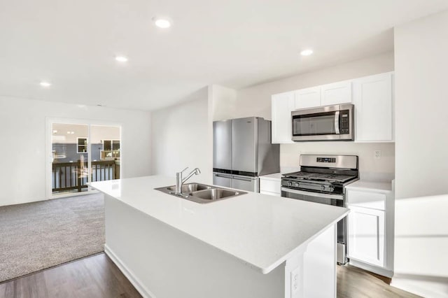 kitchen featuring stainless steel appliances, sink, a center island with sink, and white cabinets