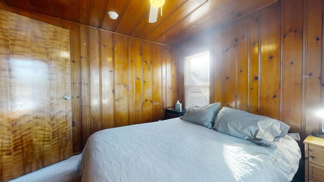 bedroom featuring wood ceiling, ceiling fan, wooden walls, and carpet floors