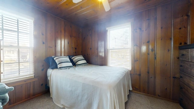 carpeted bedroom featuring wood ceiling, ceiling fan, and wood walls