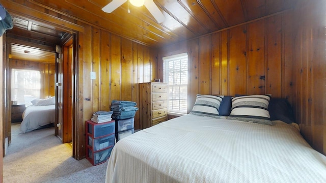 carpeted bedroom with wood ceiling, ceiling fan, and wooden walls