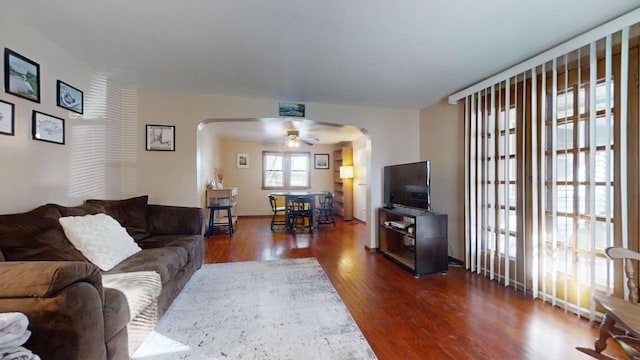 living room with dark wood-type flooring and ceiling fan