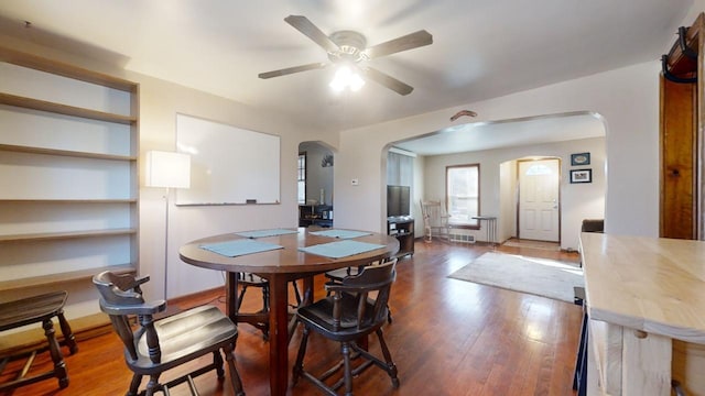 dining space with hardwood / wood-style floors and ceiling fan