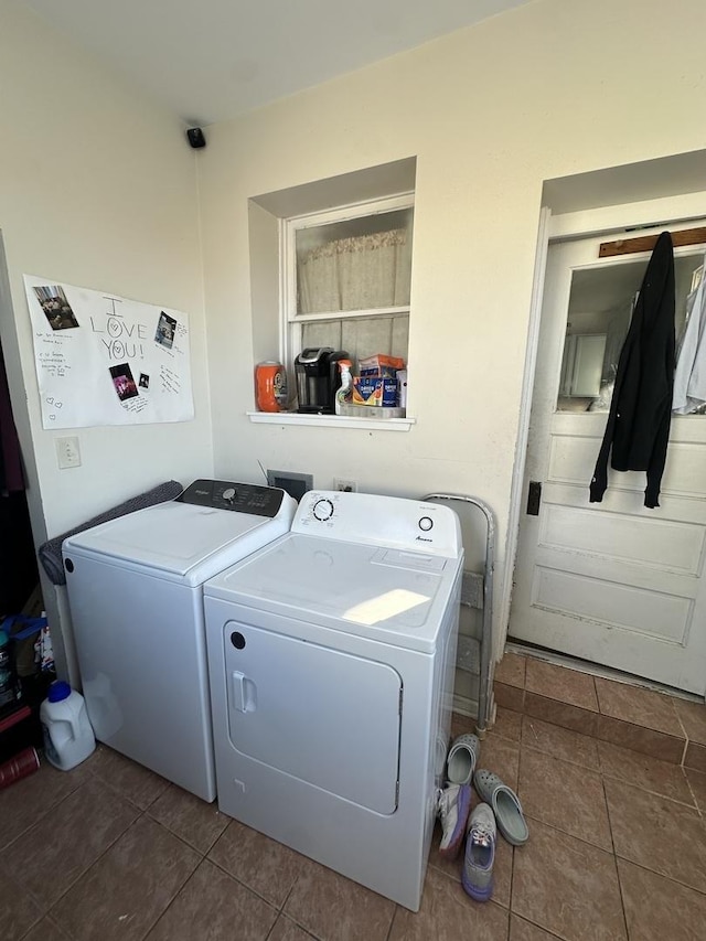 washroom featuring washer and dryer and dark tile patterned flooring