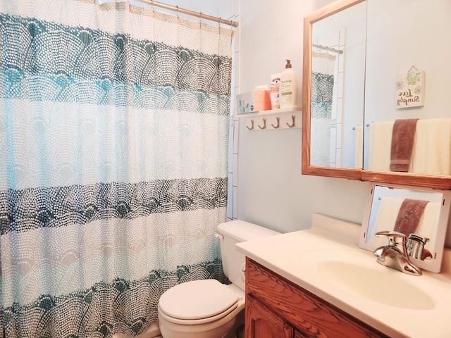 bathroom featuring a shower with curtain, vanity, and toilet