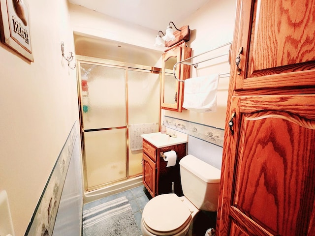 bathroom featuring walk in shower, vanity, toilet, and tile patterned flooring