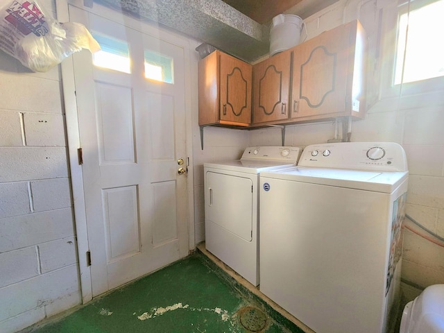 washroom with cabinets and washing machine and dryer