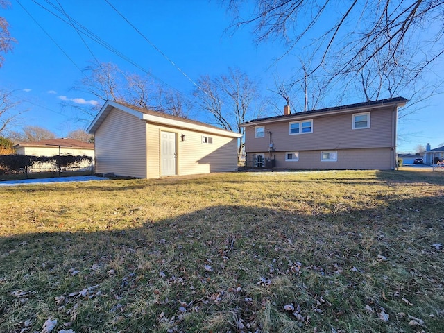 back of house with a yard and an outdoor structure