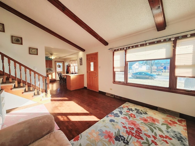 living room featuring dark hardwood / wood-style floors, ceiling fan, vaulted ceiling with beams, and a textured ceiling