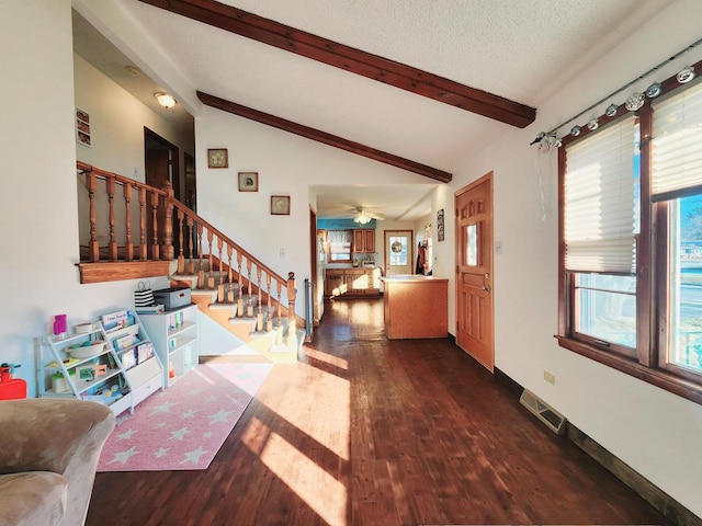 entrance foyer with vaulted ceiling with beams, dark wood-type flooring, and a textured ceiling