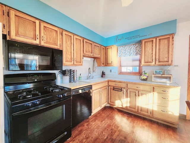 kitchen featuring wood-type flooring, sink, and black appliances