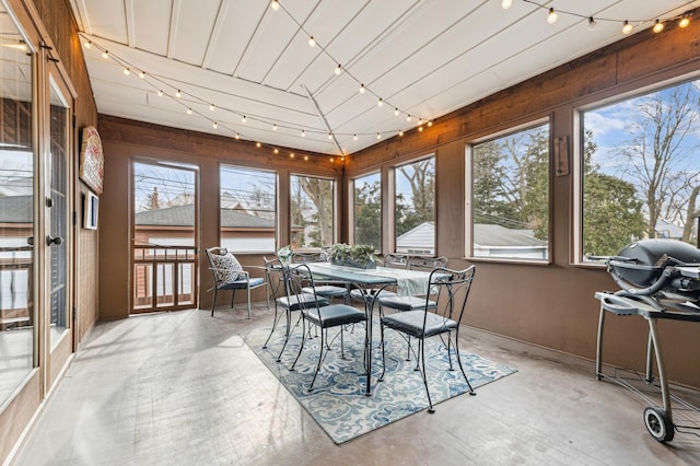 sunroom featuring vaulted ceiling and rail lighting