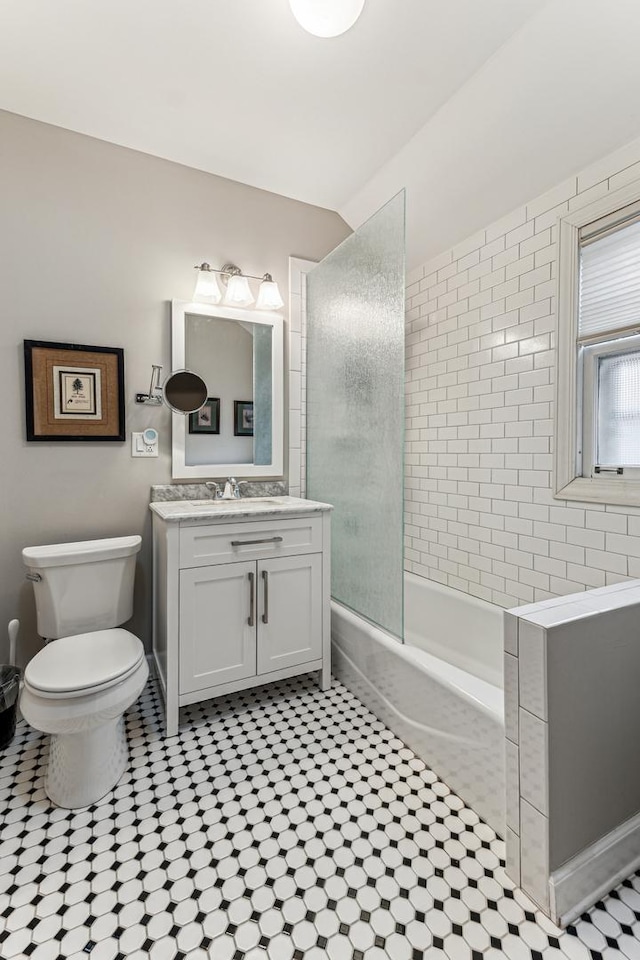 full bathroom with tiled shower / bath combo, vanity, and toilet