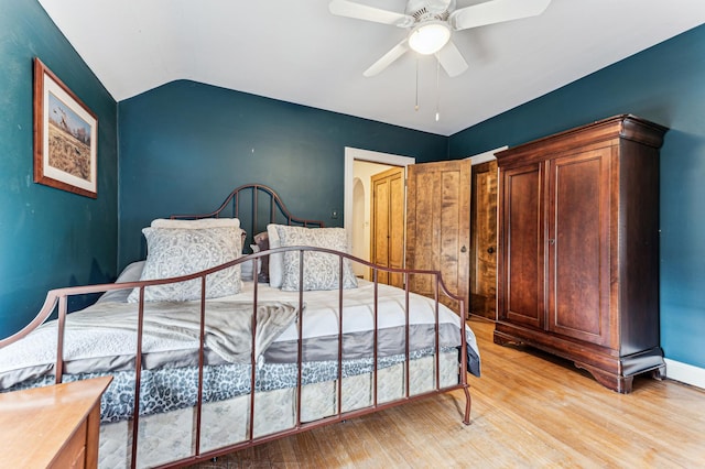 bedroom with vaulted ceiling, ceiling fan, and light wood-type flooring