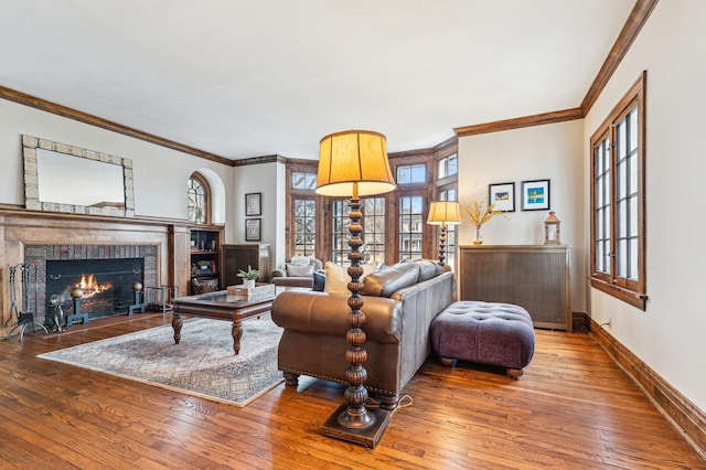 living room with ornamental molding, hardwood / wood-style floors, and a brick fireplace