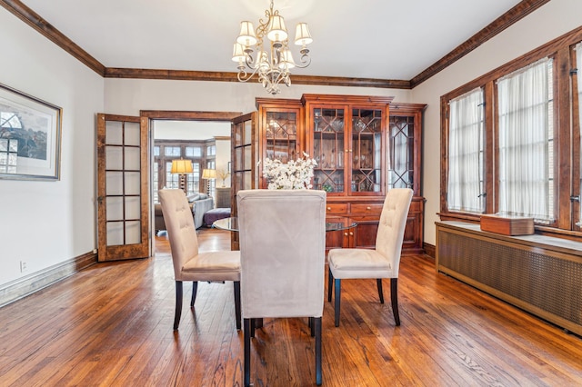 dining area with an inviting chandelier, crown molding, radiator heating unit, and dark hardwood / wood-style floors