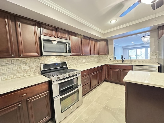 kitchen with ornamental molding, appliances with stainless steel finishes, decorative light fixtures, and sink