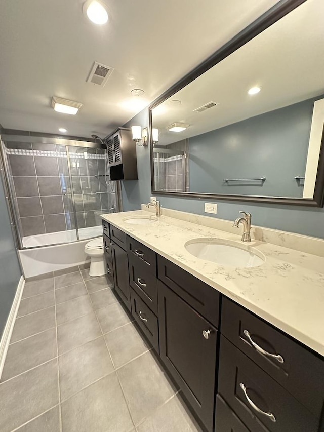 full bathroom featuring vanity, tile patterned flooring, shower / bath combination with glass door, and toilet