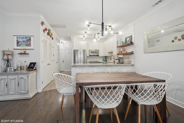 kitchen featuring white cabinetry, crown molding, tasteful backsplash, stainless steel refrigerator, and kitchen peninsula