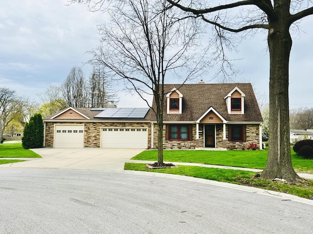 230 N Forest Ct, Palatine, IL 60074 - view of front of home with roof mounted solar panels, concrete driveway, an attached garage, stone siding, and a front yard