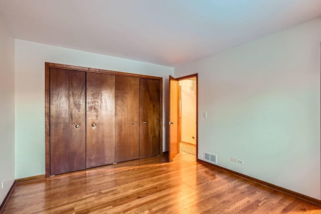 unfurnished bedroom with a closet and light wood-type flooring