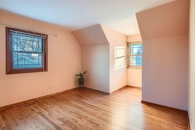 bonus room with lofted ceiling and light hardwood / wood-style flooring