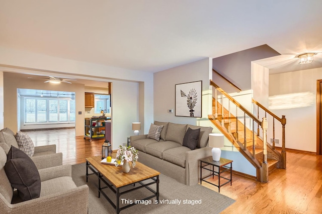 living room featuring light hardwood / wood-style flooring and ceiling fan