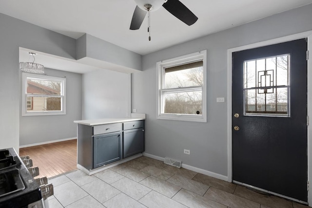 clothes washing area featuring light tile patterned flooring, ceiling fan, and plenty of natural light