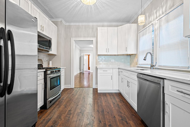 kitchen with white cabinetry, appliances with stainless steel finishes, and decorative light fixtures