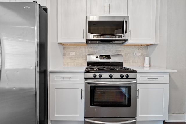 kitchen with backsplash, appliances with stainless steel finishes, and white cabinets