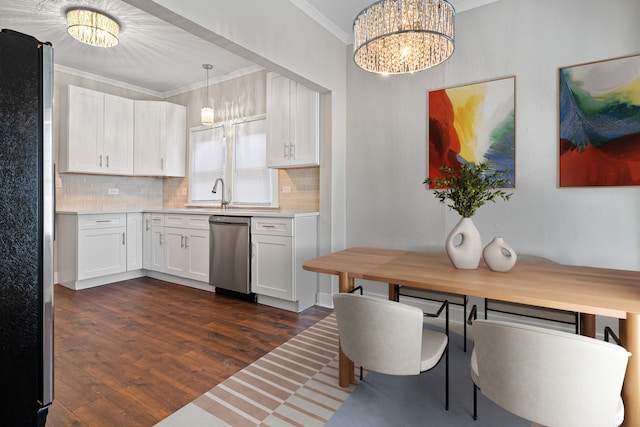 kitchen with an inviting chandelier, crown molding, decorative light fixtures, appliances with stainless steel finishes, and white cabinets