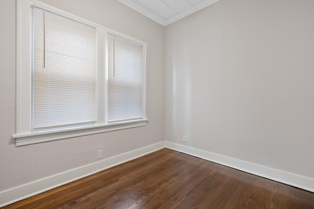 unfurnished room with ornamental molding and dark wood-type flooring