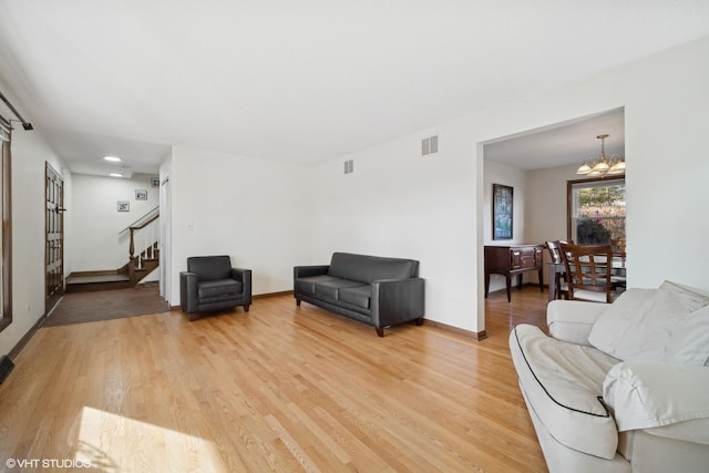 living room with hardwood / wood-style flooring and a notable chandelier