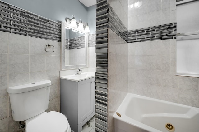 full bathroom with vanity, tiled shower / bath combo, toilet, and tile walls