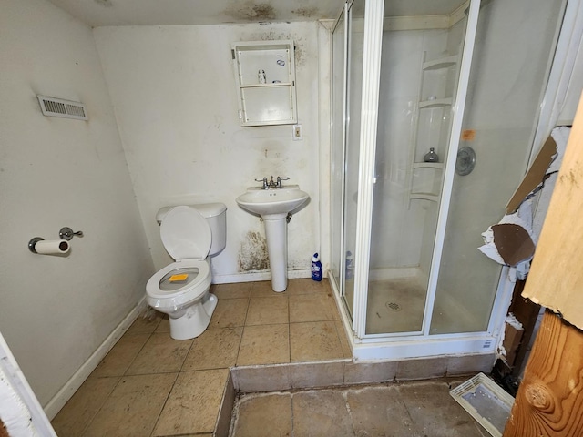 bathroom featuring sink, tile patterned floors, a shower with door, and toilet