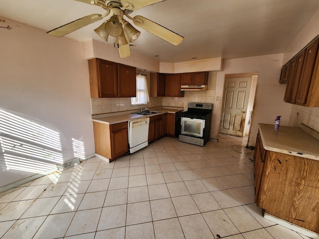 kitchen featuring gas stove, sink, light tile patterned flooring, and white dishwasher