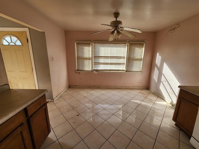 foyer entrance with light tile patterned floors, plenty of natural light, and ceiling fan