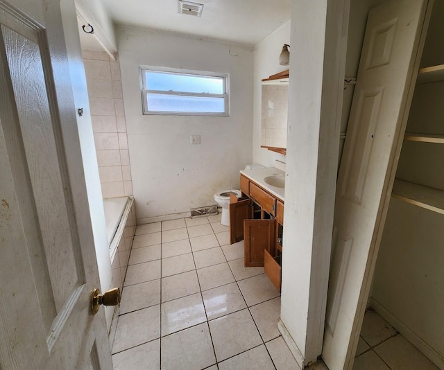 bathroom with tile patterned flooring, vanity, a bathtub, and toilet