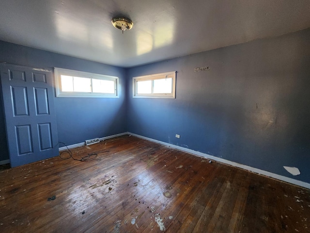 unfurnished room featuring plenty of natural light and dark hardwood / wood-style floors