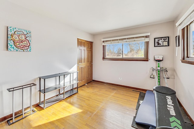 exercise area featuring baseboards and wood finished floors