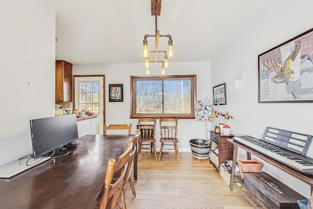 dining space with light wood-type flooring and baseboards