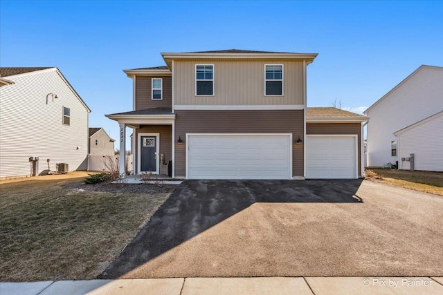 front of property featuring a garage, a front lawn, and central air condition unit