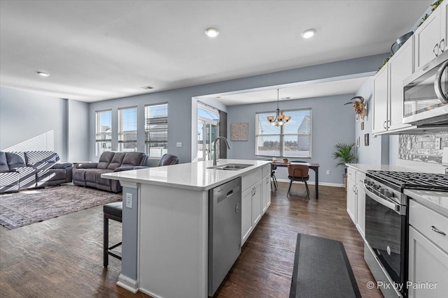 kitchen featuring sink, a center island with sink, appliances with stainless steel finishes, pendant lighting, and white cabinets