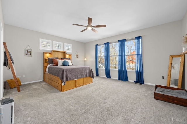 carpeted bedroom with ceiling fan and baseboards