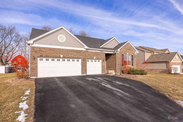 ranch-style house featuring a garage, aphalt driveway, a front lawn, and brick siding