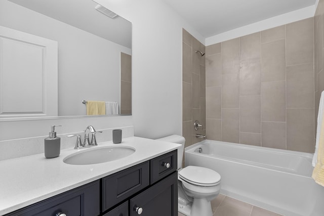 full bathroom featuring tile patterned flooring, vanity, tiled shower / bath, and toilet