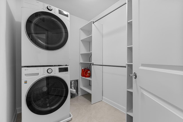 washroom with light tile patterned flooring and stacked washer / drying machine