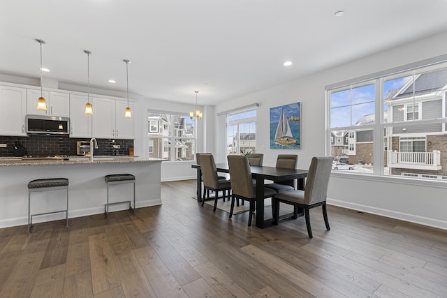 dining space featuring dark wood-type flooring and a chandelier