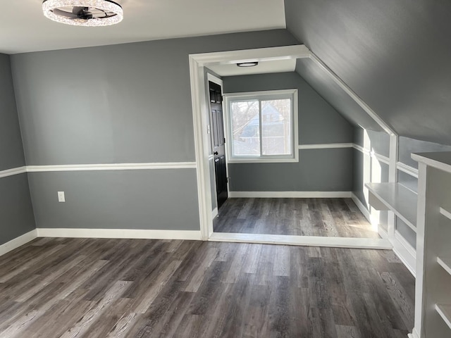 bonus room with dark hardwood / wood-style floors and vaulted ceiling